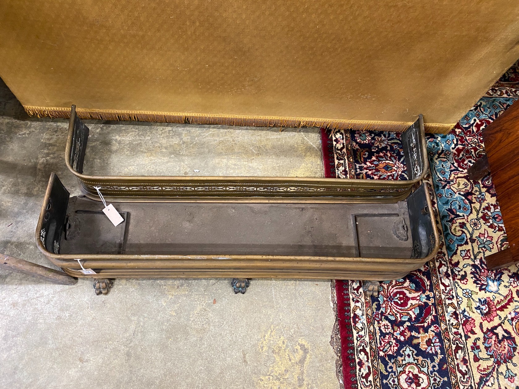 Two Victorian pierced brass fenders, larger width 121cm